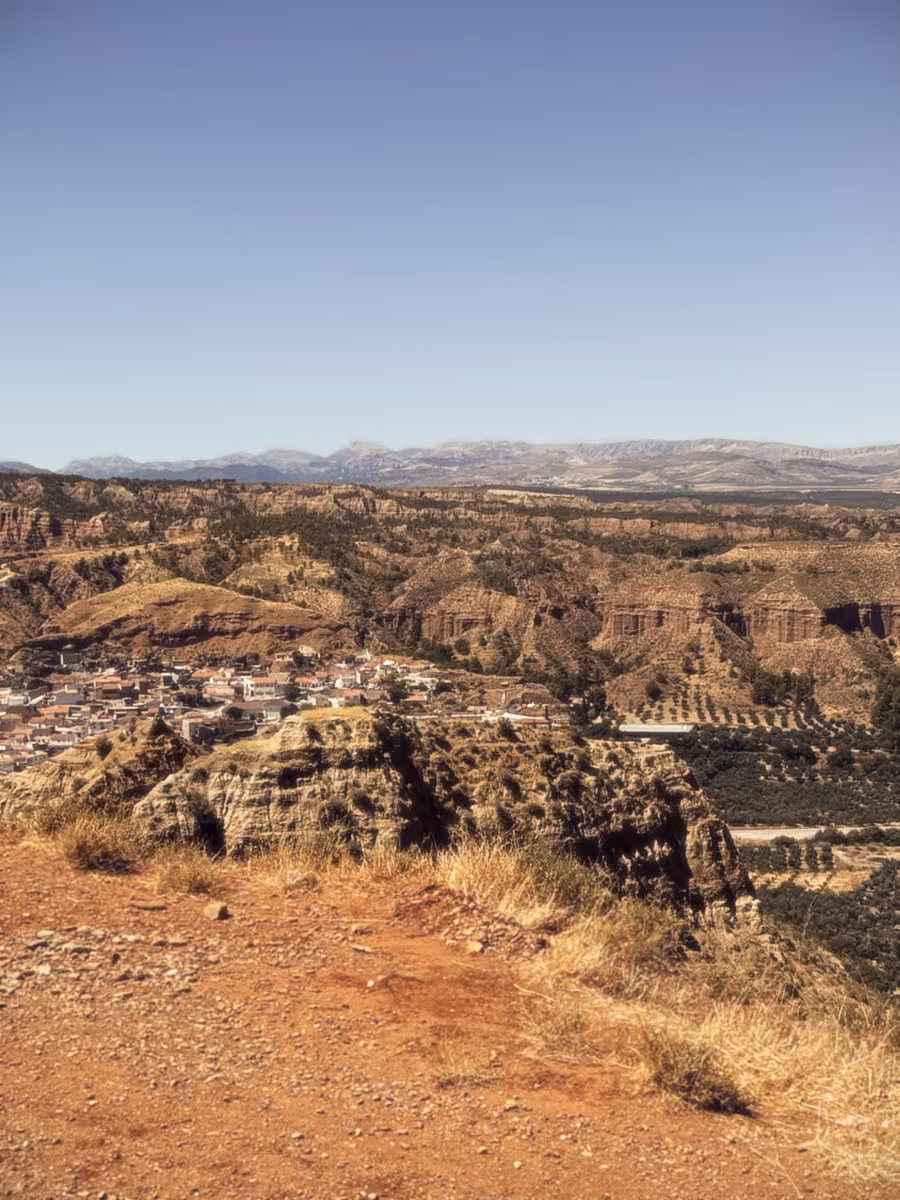 Eroded hills around Beas de Guadix, with a white village in the valley below.