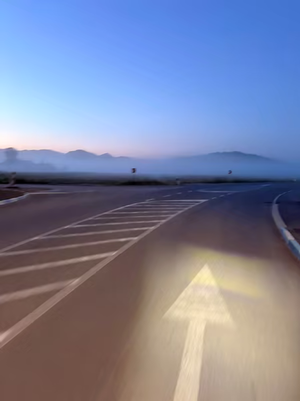 Bike headlight illuminating an empty road at dawn